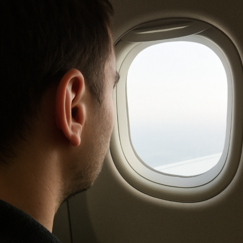 Airplane cabin window showing travel at altitude