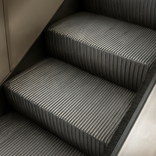 Escalator step with safety brushes along the side
